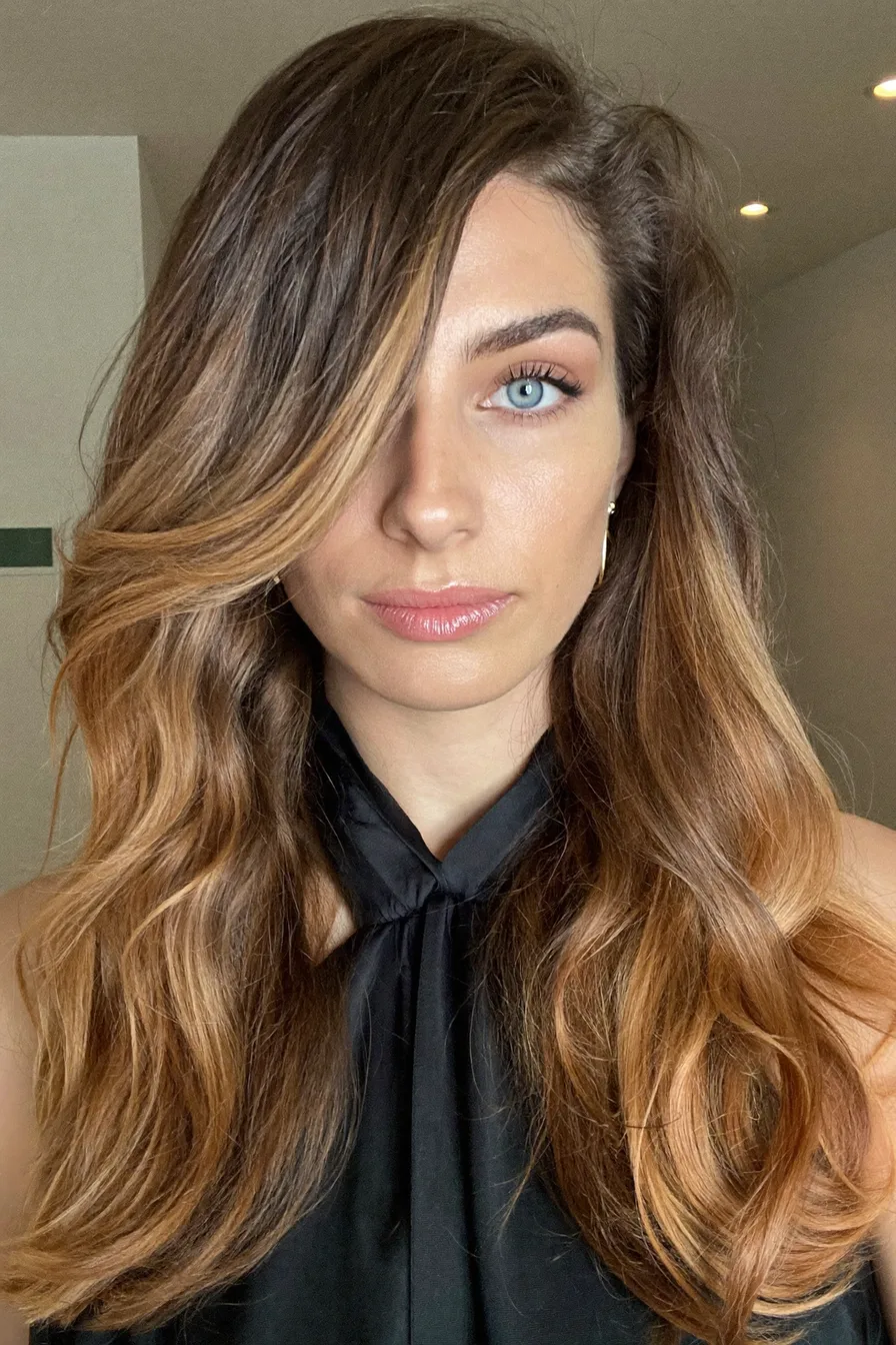 Voluminous Long Layered Haircut with Side-Swept Bangs for Effortless Glamour